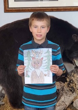 Boy holding his winning design of a deer drawing